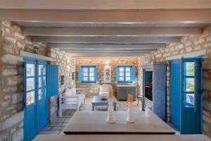 a living room with blue doors and a stone wall at Sand Key Villa 1 in Santa Maria