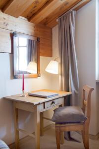 a desk in a room with a lamp and a chair at Hotel Angela in Lech am Arlberg