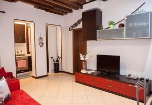 Il comprend un salon doté d'un canapé rouge et d'une télévision à écran plat. dans l'établissement Casa Melissa, à Venise