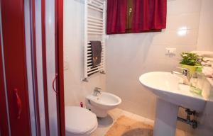 La salle de bains est pourvue de toilettes blanches et d'un lavabo. dans l'établissement Casa Melissa, à Venise