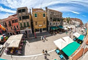 un groupe de personnes se promenant dans une rue avec des bâtiments dans l'établissement Casa Melissa, à Venise