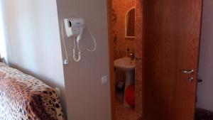 a bathroom with a toilet and a phone on the wall at Margarita Guest House in Sochi