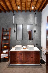 a bathroom with two sinks and two mirrors at Antique Villa in Líndos