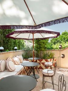 a patio with tables and chairs and an umbrella at La Bionda Hotel - Adults Only in Begur