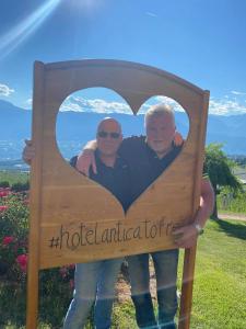 a man and woman holding a sign with a heart at Hotel Antica Torre in Coredo