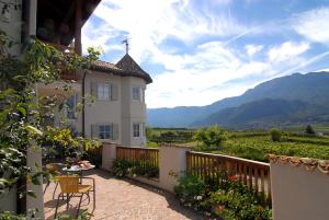 a house with a balcony with a table and chairs at Weinhof Mumelter in Appiano sulla Strada del Vino
