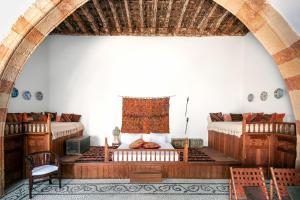 een kamer met 2 bedden en een tafel en een stoel bij Antique Villa in Lindos