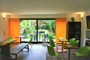 a restaurant with tables and green chairs and a large glass door at Schacht34 in Oberhausen