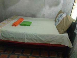 a small bed with two towels on top of it at Pousada do Melo in Atins