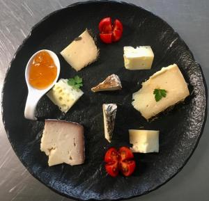 un plato de queso y tomates en una mesa en Hotel Antica Torre en Coredo