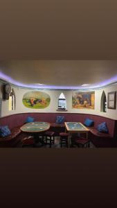 une chambre avec deux tables, des chaises et des peintures murales dans l'établissement Gurraun House, à Kilkee