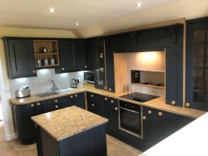 a kitchen with black cabinets and a counter top at Luxury Flat with Lovely views in Rural location in Fraserburgh