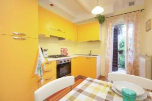Mondavio的住宿－Casa Vacanze Wellness La Rocca，厨房配有黄色橱柜和桌椅