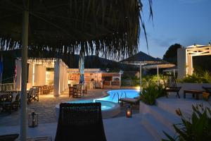 a patio with a pool and chairs and a table at Elsa Hotel in Skiathos Town