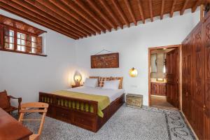 een slaapkamer met een bed, een tafel en een stoel bij Antique Villa in Lindos