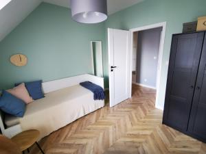 a bedroom with a bed with blue pillows on it at Trident Apartment III in Gdańsk