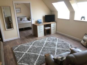 a living room with a bed and a desk with a television at Luxury Flat with Lovely views in Rural location in Fraserburgh