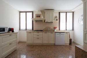 a kitchen with white cabinets and white appliances at Giglio Suite 2476 in Venice