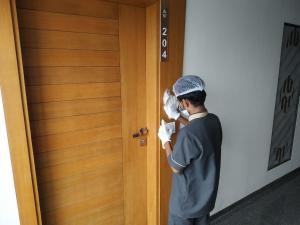 Eine Person öffnet eine Tür mit einem Taschentuch. in der Unterkunft HOTEL SATKAR CHHATRAL in Kalol