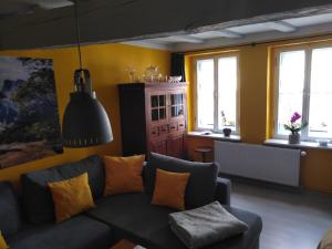 a living room with a couch and some windows at Urlaub im Fachwerkhaus in Gernrode - Harz