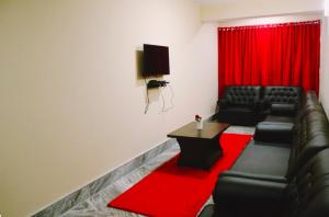 een woonkamer met zwarte lederen meubels en een rood gordijn bij Bankhim Residency (Parking available) in Gangtok