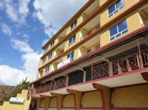 un edificio amarillo con balcones en un lateral en Bankhim Residency (Parking available), en Gangtok