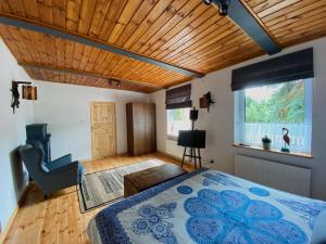 sypialnia z łóżkiem i drewnianym sufitem w obiekcie Komoda Tykocin w Tykocinie
