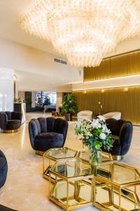 een lobby met een glazen tafel en een kroonluchter bij C-Hotels Andromeda in Oostende