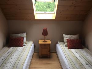 two twin beds in a room with a window at MARYSIEŃKA in Zawoja