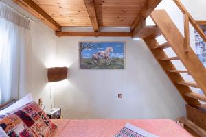 un dormitorio con una escalera y una foto de un caballo en la pared en Traditional Cretan House Lithostrati Karidi Village, en Karídhion 55 fotos más