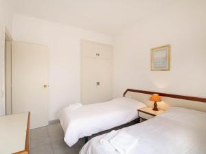 a bedroom with two beds and a lamp on a table at PORT III Sistach Rentals in L'Estartit