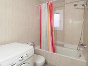 a bathroom with a toilet and a shower curtain at PORT III Sistach Rentals in L'Estartit