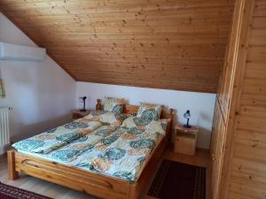 un letto in una stanza con soffitto in legno di Hévízi fecskefészek a Hévíz