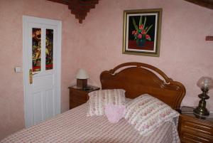 a bedroom with a bed with pink walls at Posada El Mirador in Lavín