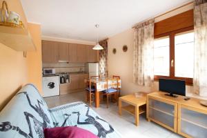 a kitchen and living room with a couch and a table at PORT I Sistach Rentals in L'Estartit