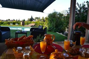 a table with a basket of bread and glasses of orange juice at La Bastide Neuve des Oliviers in La Londe-les-Maures