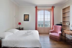 een slaapkamer met een bed, een stoel en een raam bij La Villa ker Alexis by Cocoonr - Villa Balnéaire dans Saint-Malo in Saint-Malo