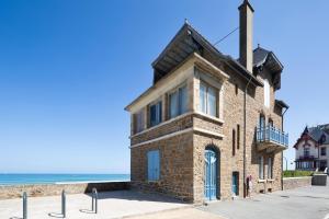 een oud bakstenen gebouw naast het strand bij La Villa ker Alexis by Cocoonr - Villa Balnéaire dans Saint-Malo in Saint-Malo