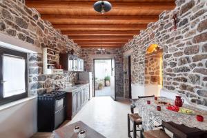 a kitchen with a stone wall and a table in a room at Traditional Cretan House Lithostrati Karidi Village in Karídhion