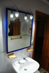 y baño con lavabo y espejo. en Posada El Mirador en Lavín