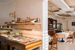 a kitchen with a table, chairs and a refrigerator at Mozart Hotel in Odesa