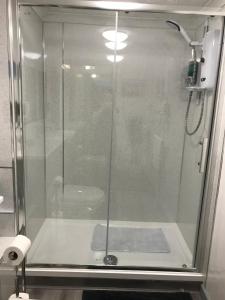 a shower with a glass door in a bathroom at Luxury 3 bedded room with sea peeps and parking in Paignton