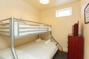 a bunk bed room with two bunk beds and a television at Cherry Property - Pear Suite in Blackpool