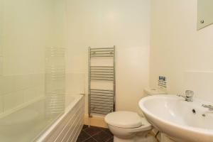 a bathroom with a toilet and a sink and a tub at Cherry Property - Pear Suite in Blackpool