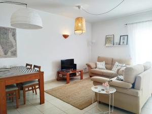 Tavira Lovers - City Centre Apartments في تافيرا: غرفة معيشة مع أريكة وطاولة