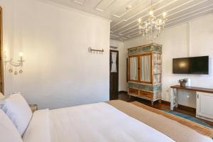 a bedroom with a white bed and a tv at Trilye Bay C Konak in Bursa