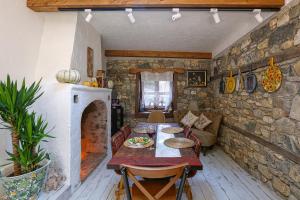 a dining room with a table and a stone wall at Trilye Bay C Konak in Bursa