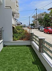 a balcony with a bench on the side of a building at Steps to the sea in Nea Peramos