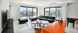 uma sala de estar com um sofá, uma mesa e cadeiras em Residenza Leca Colonna em Ajaccio