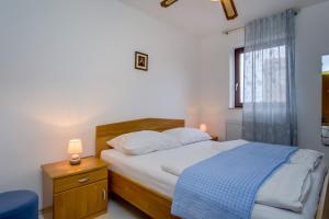 a bedroom with a bed with a blue blanket at Apartments Anci in Mali Lošinj